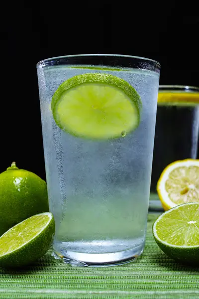 Glass with cold sparkling mineral water, lime and lemon — Stock Photo, Image