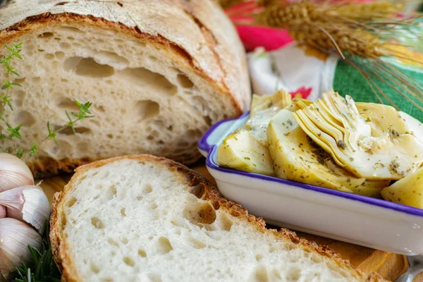 Zelfgemaakte vers Italiaans brood en artisjokken in pekel met kruiden — Stockfoto