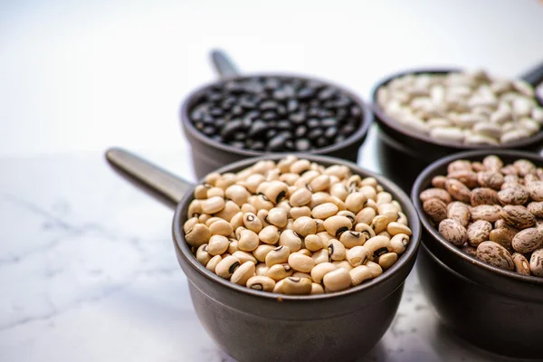 Variedad de frijoles / diferentes tipos de frijoles sobre fondo de madera negro — Foto de Stock