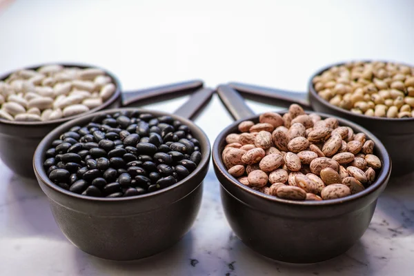 Variedad de frijoles / diferentes tipos de frijoles sobre fondo de madera negro — Foto de Stock