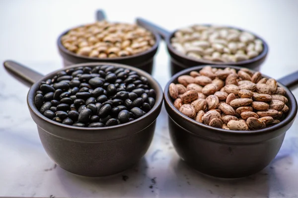 Variedad de frijoles / diferentes tipos de frijoles sobre fondo de madera negro — Foto de Stock