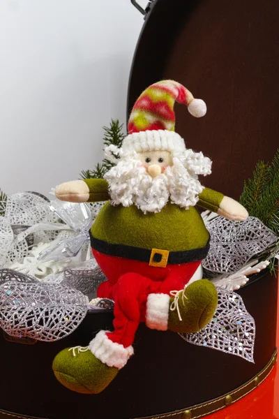 Santa Claus sits on vintage brown coffer with white christmas tree — Stock Photo, Image