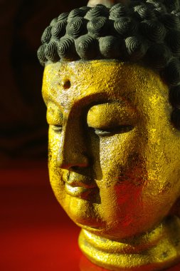 Kopya alanı koyu kırmızı zemin üzerine altın Buddha sakin yüz