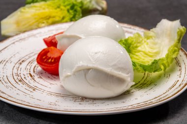 cheese collection, balls on soft white mozzarella buffala cheese served with green cos lettuce and tomato close up clipart