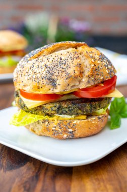 Taze ve sağlıklı vejetaryen hamburgerleri ızgara ıspanak ya da balkabağı burgerleri, organik çörekler ve sebzelerle yemek.