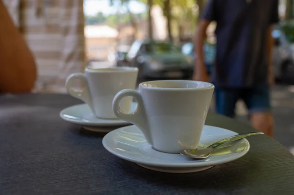 Drinking of strong black espresso coffee on outdoor terrace in cafe close up