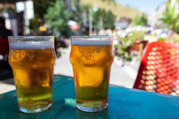French cold beer in misted glasses served on outdoor terrace in small Alpine village in France close up