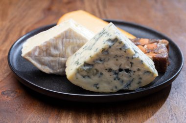 Peynir koleksiyonu, küflü peynir, peynirli krema, peynirli tatlı olarak sunulan incirli badem ekmeği.