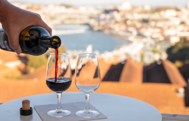 Güçlendirilmiş tatlı yakutu, Douro nehrinin manzaralı tawny porto şarapları, Vila Nova de Gaia 'nın porto locaları ve gün batımında Portekiz' in Porto kenti.