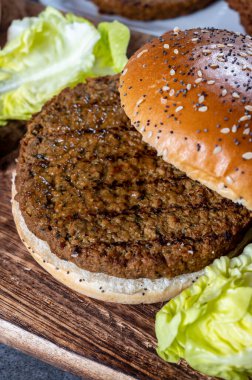 Bitki temelli ızgara burgerler, taze fırınlanmış çörekler ve organik sebzelerden lezzetli vejetaryen hamburgerler yapıyorum.