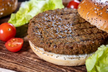 Bitki temelli ızgara burgerler, taze fırınlanmış çörekler ve organik sebzelerden lezzetli vejetaryen hamburgerler yapıyorum.