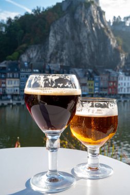 Koyu ve güçlü Belçika manastırı birası içmek güneşli bir günde Maas nehri manzaralı güzel manzaralı Belçika Dinant, Belçika