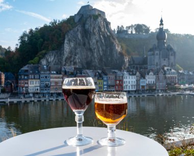 Koyu ve güçlü Belçika manastırı birası içmek güneşli bir günde Maas nehri manzaralı güzel manzaralı Belçika Dinant, Belçika