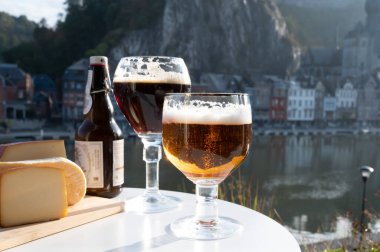 Koyu ve güçlü Belçika manastırı birası içmek güneşli bir günde Maas nehri manzaralı güzel manzaralı Belçika Dinant, Belçika