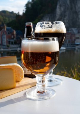 Koyu ve güçlü Belçika manastırı birası içmek güneşli bir günde Maas nehri manzaralı güzel manzaralı Belçika Dinant, Belçika