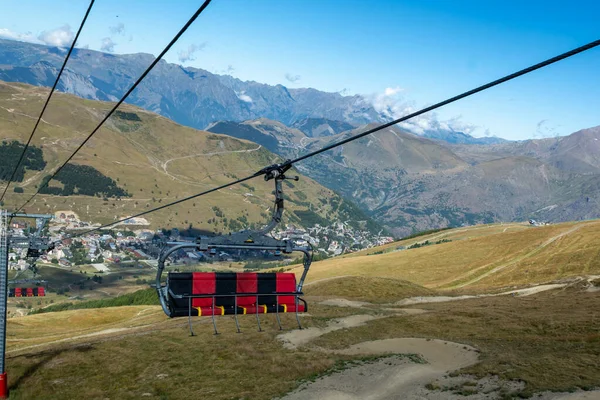 Ski lift near winter and summer sport station Les deux Alpes and view on Alpine mountains peaks in summertime, Ecrins range,  Isere, France