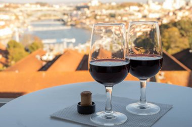 Farklı tahkim edilmiş tatlı yakutlarının, Douro nehrinin manzaralı tawny porto şaraplarının, Vila Nova de Gaia 'nın porto localarının ve Portekiz' in Porto şehrinin günbatımında tadına bakmak.