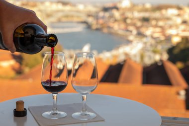Güçlendirilmiş tatlı yakutu, Douro nehrinin manzaralı tawny porto şarapları, Vila Nova de Gaia 'nın porto locaları ve gün batımında Portekiz' in Porto kenti.