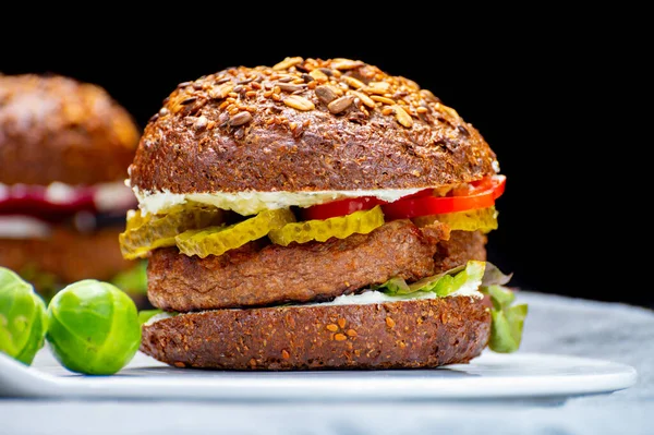 Vegan hamburgers with grilled healthy plant based, meat free burgers and fresh vegetables