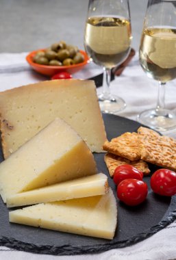 İspanyol İspanyol tapası, manchego peyniri, yeşil zeytin bardakta sek fino şeri şarabı. Yakın plan.