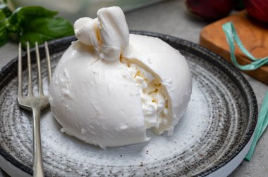 Puglia 'dan taze el yapımı İtalyan peyniri yemek, beyaz burrata topları veya mozzarella ve kremadan yapılmış burratina peyniri yemek.