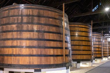 Portekiz 'in kuzeyindeki Vila Nova de Gaia' da güçlendirilmiş yakut ya da tawny porto şarabının yavaş yaşlanması için meşe ağacı fıçılarıyla dolu eski bir porto kulübesi.