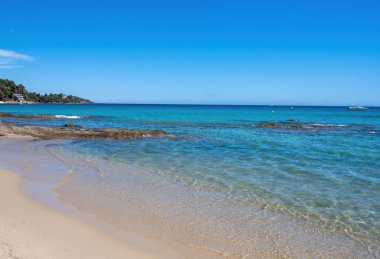 Fransız Riviera 'sında yaz tatili, Akdeniz' in berrak masmavi suları Le Lavandou, Var, Provence, Fransa yakınlarındaki Saint Clair 'de beyaz kumlu plajlar.
