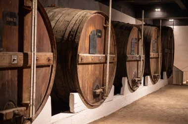 Portekiz 'in kuzeyindeki Vila Nova de Gaia' da güçlendirilmiş yakut ya da tawny porto şarabının yavaş yaşlanması için meşe ağacı fıçılarıyla dolu eski bir porto kulübesi.