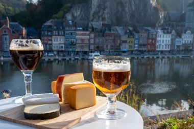 Koyu ve güçlü Belçika manastırı birası içmek güneşli bir günde Maas nehri manzaralı güzel manzaralı Belçika Dinant, Belçika