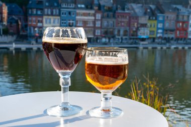 Koyu ve güçlü Belçika manastırı birası içmek güneşli bir günde Maas nehri manzaralı güzel manzaralı Belçika Dinant, Belçika