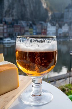 Koyu ve güçlü Belçika manastırı birası içmek güneşli bir günde Maas nehri manzaralı güzel manzaralı Belçika Dinant, Belçika