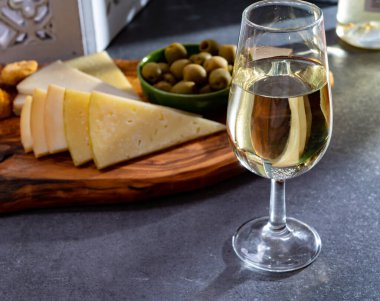 Tasting of fortified Andalusian fino sherry wine with traditional Spanisch tapas, green olives, goat and sheep manchego cheese clipart