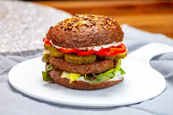 Vegan hamburgers with grilled healthy plant based, meat free burgers and fresh vegetables