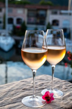 Yaz günbatımında yerel soğuk gül şarabının tadına bakmak arka planda liman, Provence, Var, Fransa