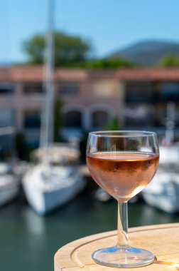 Yaz mevsiminde yerel soğuk gül şarabının tadına bakmak arka planda liman grimaud limanı, Provence, Var, Fransa