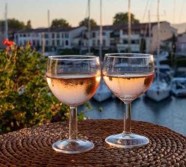 Yazın günbatımında yerel soğuk gül şarabı içmek arka planda liman, Provence, Var, Fransa