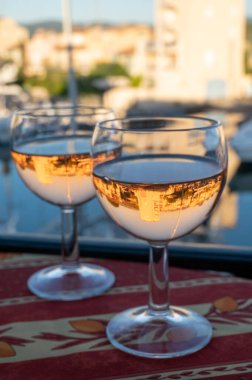 Yaz mevsiminde yerel soğuk gül şarabı içerken arka planda liman, Provence, Var, Fransa