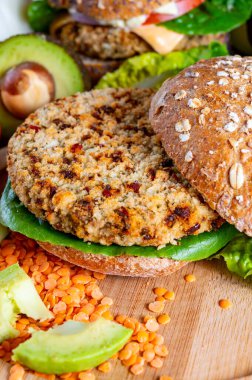 Lezzetli vejetaryen sağlıklı yeşil yemek, portakallı mercimeklerden yapılmış ev yapımı hamburgerler yeşil marul ve taze olgun avokado.