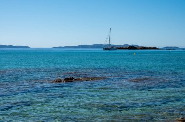 Fransız Riviera 'sında yaz tatili, Akdeniz' in berrak masmavi suları Le Lavandou, Var, Provence, Fransa yakınlarındaki Saint Clair 'de beyaz kumlu plajlar.