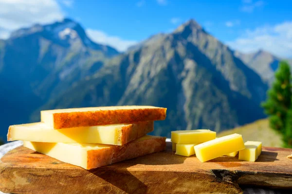 夏にアルプスの山々の峰を背景に屋外で提供されるチーズコレクション フランスのコメ 美しさ または豊富な牛のミルクチーズ — ストック写真