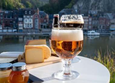 Koyu ve güçlü Belçika manastırı birası içmek güneşli bir günde Maas nehri manzaralı güzel manzaralı Belçika Dinant, Belçika