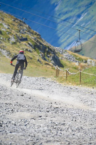 Extreem outdoor sport challenge in French Alps mountains in summer, riding downhill on sport bike on special bicycle path, Les deux Alpes station