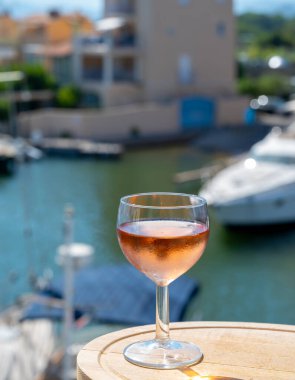 Yaz mevsiminde yerel soğuk gül şarabının tadına bakmak arka planda liman grimaud limanı, Provence, Var, Fransa