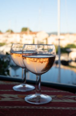 Yaz mevsiminde yerel soğuk gül şarabı içerken arka planda liman, Provence, Var, Fransa