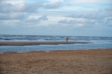Sörfçü, Hollanda 'nın Zandvoort kenti yakınlarındaki Kuzey Denizi' nin soğuk suyu üzerindeki eğitimini kışın tamamladı.