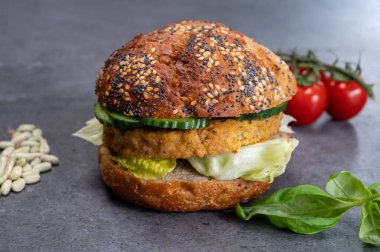 Sebze bazlı hamburgerle yapılan lezzetli vejetaryen öğle yemeği, tohumlu organik çörek ve taze sebze ve kızarmış patates.