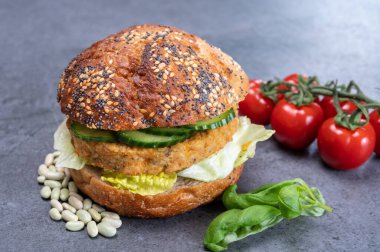 Sebze bazlı hamburgerle yapılan lezzetli vejetaryen öğle yemeği, tohumlu organik çörek ve taze sebze ve kızarmış patates.