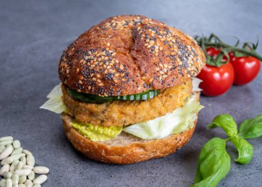 Sebze bazlı hamburgerle yapılan lezzetli vejetaryen öğle yemeği, tohumlu organik çörek ve taze sebze ve kızarmış patates.