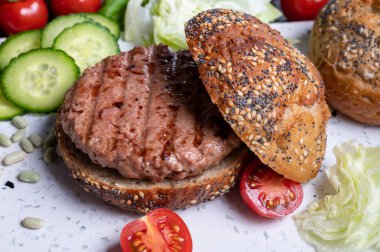 Bitki bazlı soya fasulyesi burgerinden lezzetli vejetaryen hamburger, tohumlu organik çörek ve taze sebze.