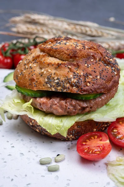 Bitki bazlı soya fasulyesi burgerinden lezzetli vejetaryen hamburger, tohumlu organik çörek ve taze sebze.